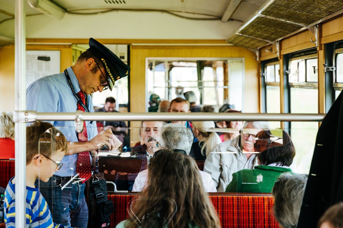 Fahrgäste und Kontrolleur bei einer Fahrt mit der Chiemgauer Lokalbahn 